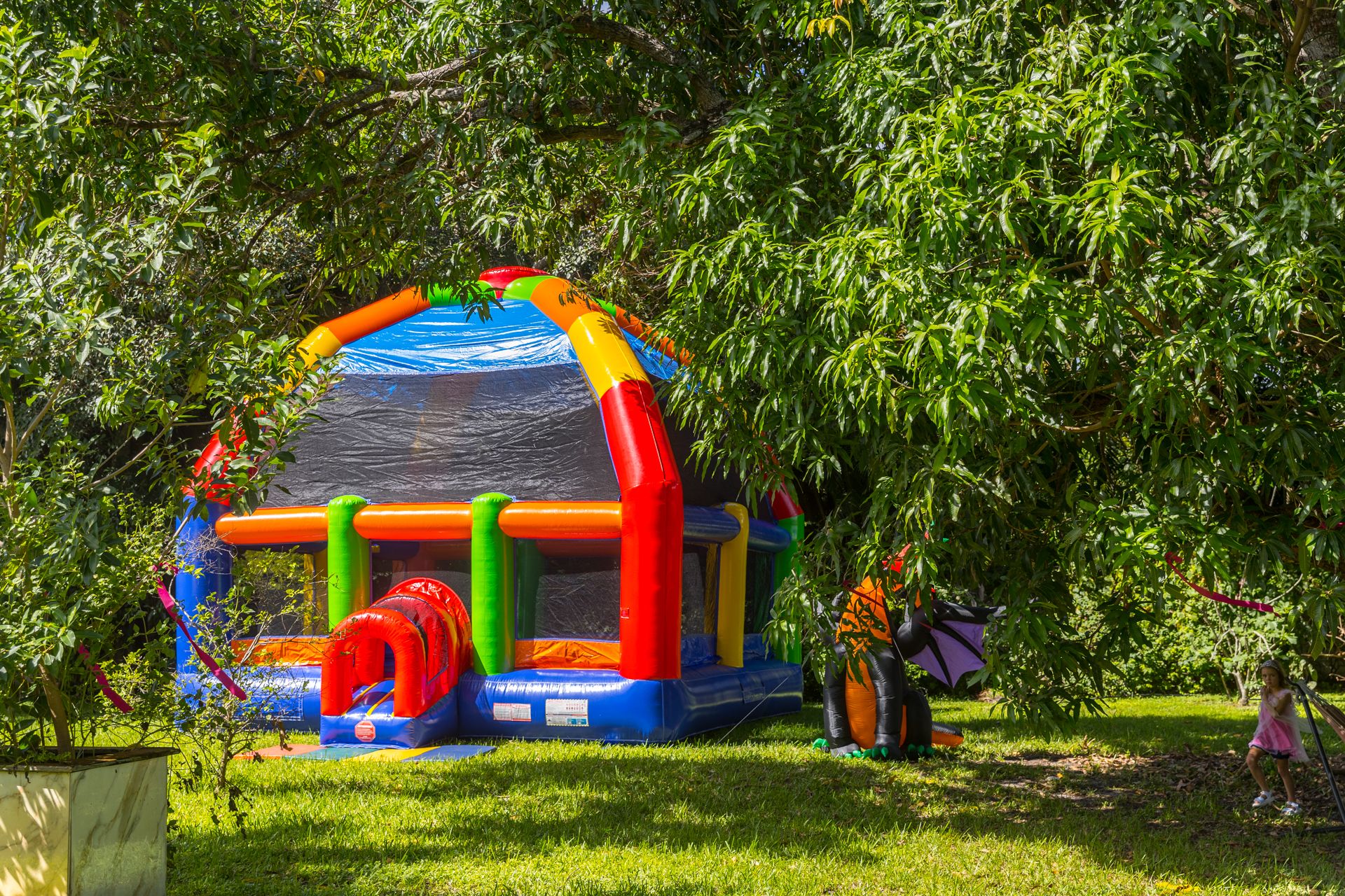The inflatable trampoline set up in a shaded garden
